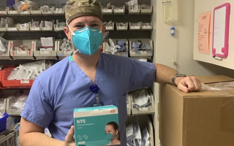 Brad Butler, MD, holds a new box of N95 masks.