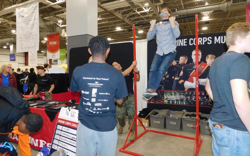 Branches of the armed services test physical prowess with pull-ups, football toss