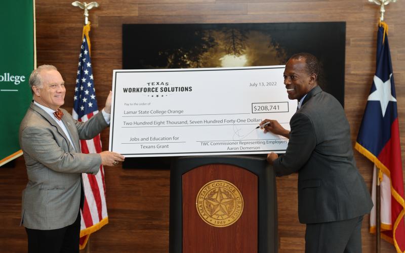 TWC Commissioner Representing Employers Aaron Demerson (right) signs and presents a JET Grant check to Lamar State College President Dr. Tom Johnson.
