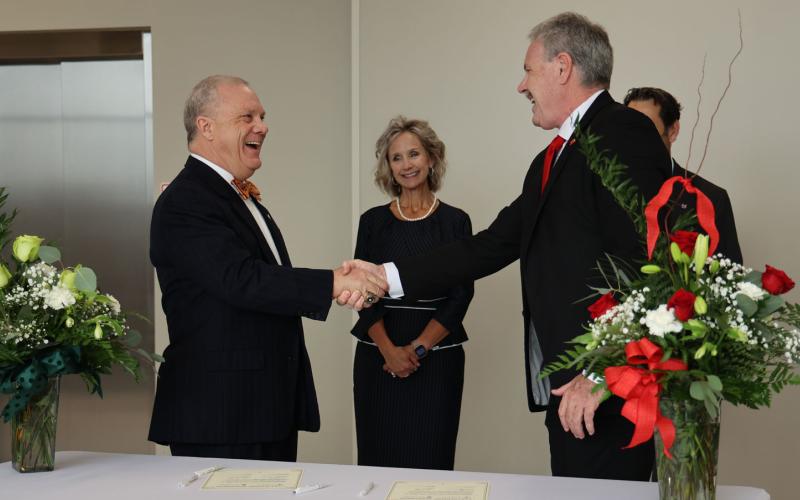 LCSO President Dr. Tom Johnson (left) and Lamar University President Dr. Jaime Taylor shake hands after signing a partnership agreement between the two schools. Looking on is LSCO Provost and Executive Vice President Dr. Wendy Elmore, the new LCSO president after Johnson’s retirement.