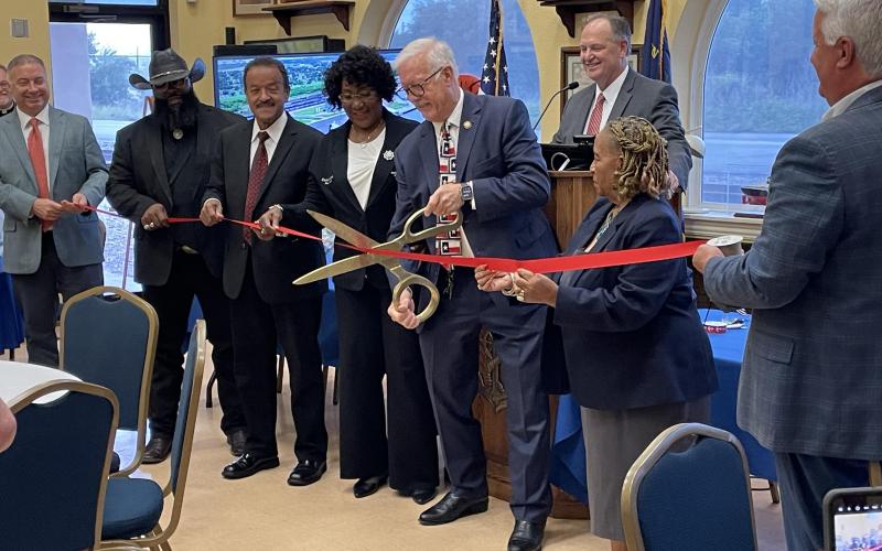 Port of Port Arthur officals watch as Congressman Raady Weber cuts the ribbon during a May 9 dedication ceremony. The ribbon cutting was conducted inside due to the weather. Photo by Dannie Oliveaux