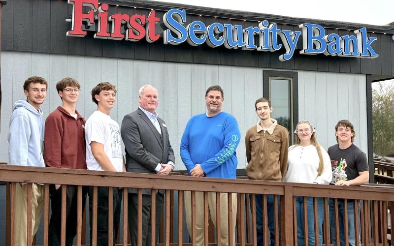 Standing with First Security Bank CEO Clint Walters and Mike Fogo, rocket instructor (center) are (from left) Hardin-Jefferson High School students Benjamin Harris, Grayson Sullivan, Kain Tinney, Westen Williams, Jayna Ivey and Tatum Brasseaux. Courtesy Image | First Security Bank
