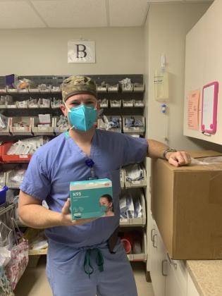 Brad Butler, MD, holds a new box of N95 masks.