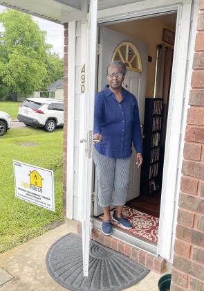 Rosa Hubbard opens the storm door that was installed during the weatherization of her home on Niecy Street.  Photo by Dannie Oliveaux
